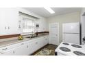 Functional kitchen with white cabinets, countertops, and updated appliances at 931 Eastern Ave, Nashville, NC 27856