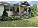Charming yellow home with a welcoming front porch, number and manicured landscaping at 9439 Clayton Blvd, Clayton, NC 27520