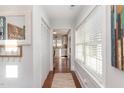 Bright hallway featuring hardwood floors, large windows, and closet with easy access to the kitchen at 109 N Watauga Ave, Dunn, NC 28334