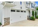 Spacious two-car garage with stone accents and manicured landscaping at 1124 Cedar Farm Trl, Fuquay Varina, NC 27526