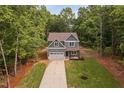 Aerial view of a two-story home with a garage, surrounded by a lush landscape at 114 Crow Dr, Louisburg, NC 27549