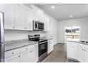 Modern kitchen featuring stainless steel appliances, ample counter space, and sleek white cabinets at 11640 International Dr, Middlesex, NC 27557