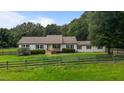 Inviting home with a warm-toned roof, freshly painted exterior, and a classic country fence at 1167 John D Winstead Rd, Roxboro, NC 27574