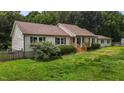 Well-maintained home featuring wood accents, lush landscaping, and a cozy front porch at 1167 John D Winstead Rd, Roxboro, NC 27574
