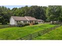 Charming home with a well-manicured lawn and a classic picket fence, surrounded by mature trees at 1167 John D Winstead Rd, Roxboro, NC 27574