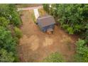 Aerial view of a blue home with a long driveway, surrounded by lush trees at 125 Oswego Dr, Louisburg, NC 27549