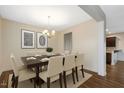 Bright dining room with modern chandelier, neutral color palette, and seating for eight at 131 Hawick Ct, Zebulon, NC 27597