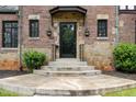 Inviting front entrance with stone steps, decorative sconces, and black framed glass door at 1541 Caswell St, Raleigh, NC 27608