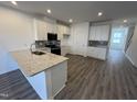 Open concept kitchen with stainless steel appliances, granite countertops and wood floors at 1945 Plott Balsam Dr, Wendell, NC 27591