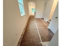 Bright hallway leads to living area, showcasing natural light and prepped flooring ready for finishing at 1985 Rabbitbrush St, Durham, NC 27704