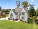 Well-manicured lawn and landscaping enhance this home's curb appeal, with a brick and white facade at 217 Dublin Rd, Raleigh, NC 27609