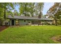 Spacious backyard featuring a well-maintained lawn, mature trees, and a patio area perfect for outdoor gatherings at 402 Forest Rd, Oxford, NC 27565