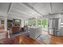 Open living area with exposed beams, fireplace, island, and sliding door to the back yard at 402 Forest Rd, Oxford, NC 27565