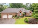 Traditional brick home featuring manicured landscaping, a two-car garage, and an American flag at 414 Bakewell Ct, Wake Forest, NC 27587