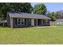 Well-maintained single-story home with a lush green lawn, beautiful siding, and manicured shrubbery at 420 E Grandview Ave, Liberty, NC 27298