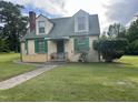 Two-story cottage with green trim, inviting porch, and well-manicured lawn, creating a picturesque and welcoming atmosphere at 45 Perkinson St, Kittrell, NC 27544