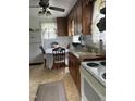 Cozy kitchen featuring a vintage stove, white appliances, wood cabinets, and a quaint dining area for a nostalgic touch at 45 Perkinson St, Kittrell, NC 27544