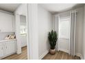 Hallway featuring an interior door and window with white trim and neutral-toned walls and hardwood floors at 537 Folk Song Way, Wendell, NC 27591