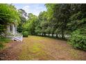 Spacious backyard with lush trees providing ample shade and privacy at 5601 Buffaloe Rd, Raleigh, NC 27616