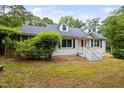 Quaint home boasting a screened in porch, lush shrubbery and dormer windows at 5601 Buffaloe Rd, Raleigh, NC 27616
