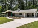 Side view showing the home's brick facade, modern carport, and spacious driveway at 5809 Kimbal St, Raleigh, NC 27606
