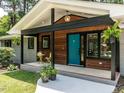 Welcoming covered porch with wood accents and a vibrant teal front door at 5809 Kimbal St, Raleigh, NC 27606