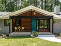 Inviting covered porch with wood accents and a vibrant teal front door at 5809 Kimbal St, Raleigh, NC 27606