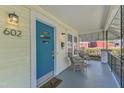 Inviting front porch featuring stylish wicker seating, a blue front door, and charming details at 602 Dunbar St, Durham, NC 27701