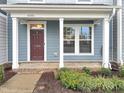 Inviting front porch with a red front door, white columns, and beautiful plantings at 6536 Perry Creek Rd, Raleigh, NC 27616
