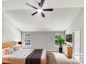 Bright bedroom featuring a ceiling fan, two windows offering ample natural light, and neutral décor at 735 Sycamore Springs Dr, Fuquay Varina, NC 27526