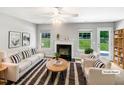 Bright living room with fireplace, neutral colors, and large windows overlooking a green backyard at 735 Sycamore Springs Dr, Fuquay Varina, NC 27526
