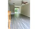 Bright living room with updated flooring, sliding glass doors, and a ceiling fan at 7832 Averette Field Dr, Raleigh, NC 27616