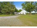 Scenic shot of a charming single-story home with front porch, a well-manicured lawn, and surrounding trees at 784 Crawford Rd, Coats, NC 27521