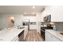 Bright kitchen with white cabinets, granite countertops, stainless steel appliances, and hardwood floors at 812 Ottawa Dr, Garner, NC 27529