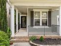 Welcoming covered front porch with black railings and brick trim at 904 Pirouette Ct, Raleigh, NC 27606
