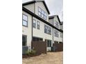 Rear view of modern townhomes with neutral siding, dark trim, and fenced patios at 980 Double Helix Rd, Apex, NC 27523