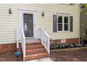 Close up shot of the front porch, brick steps, and garden in front of the yellow home at 1 Old Towne Pl, Durham, NC 27713