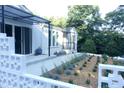 Landscaped exterior with a view of the home's entry, modern railings, and mature trees at 100 Eastwood Lake Rd Rd, Chapel Hill, NC 27514