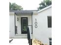 Home's front entrance featuring a modern awning, contemporary address numbers, and stylish black door at 100 Eastwood Lake Rd Rd, Chapel Hill, NC 27514