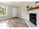 Cozy living area with wood floors, a fireplace, and great natural light from the window at 1033 Sagamore Dr, Louisburg, NC 27549