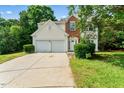 Two-story home with a two-car garage, brick and cream-colored siding, and manicured lawn at 107 Woolard Way, Apex, NC 27502