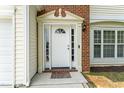 Elegant front door with decorative trim, sidelights, and a transom window, set in brick facade at 107 Woolard Way, Apex, NC 27502