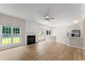 Bright, open-plan living room with hardwood floors, a fireplace, and large windows at 107 Woolard Way, Apex, NC 27502