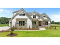 Charming two-story home features board and batten siding and stone accents, set on a well-manicured lawn at 120 Firefly Ln, Louisburg, NC 27549