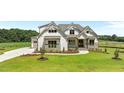 Charming two-story home features board and batten siding and stone accents, set on a well-manicured lawn at 120 Firefly Ln, Louisburg, NC 27549