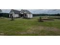 Spacious home with pristine lawn, landscaping, and exterior stone accents at 120 Firefly Ln, Louisburg, NC 27549