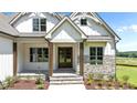 Inviting front entrance features double doors and stone accents, enhanced by a covered porch at 120 Firefly Ln, Louisburg, NC 27549