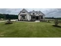 Beautiful two-story home with manicured lawn and elegant stone accents at 120 Firefly Ln, Louisburg, NC 27549