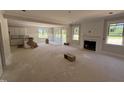 Spacious living room with a fireplace, large windows, and access to the kitchen and backyard at 145 Tee Dr, Selma, NC 27576