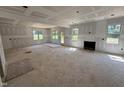 Bright living room featuring a fireplace, large windows, and a door to the backyard at 145 Tee Dr, Selma, NC 27576